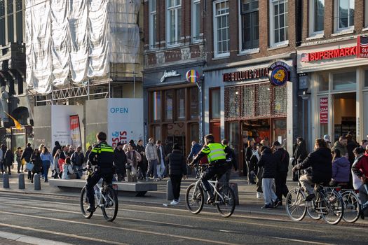 Winkelend publiek in het centrum tijdens koopzondag Bestamsterdam met geopende winkels en terrassen