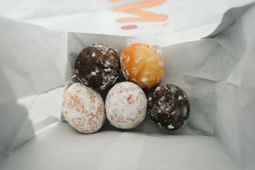 Dunkin donuts winkel in Amsterdam met vitrine vol donuts en koffiebekers bij een druk stationsgebied