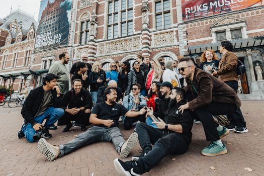 Smartphone met nu.nl op het scherm bij een tramhalte in Bestamsterdam