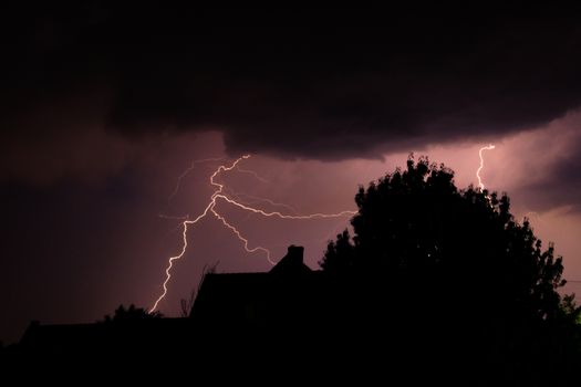 Donkere lucht boven Bestamsterdam met onweersbuien, natte weg en langzaam rijdend verkeer