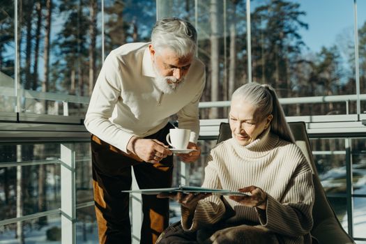 Werkende man en vrouw bekijken samen hun pensioenopbouw en financiële planning aan de keukentafel