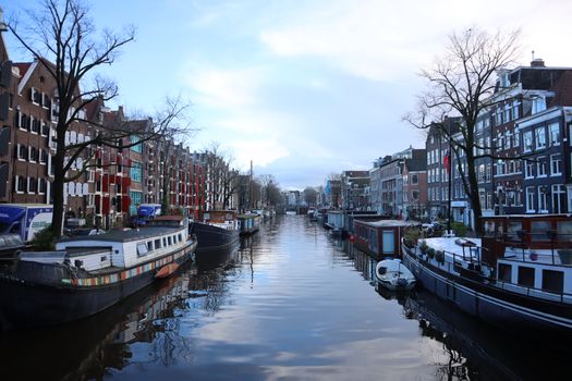 Straatbeeld bij de Dam met wolken en wind, passend bij het weer van vandaag amsterdam